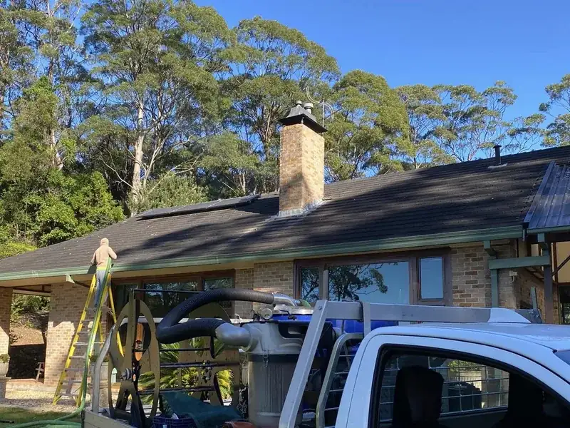Gutter cleaning by Ed's Property Maintenance beside the brick chimney and roofline of a Shoalhaven home
